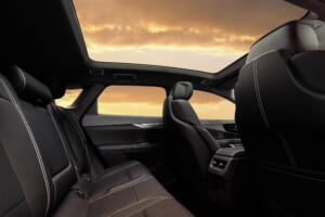 View of 2025 Cadillac OPTIQ interior showing the second-row seating with segment-best spaciousness and fixed glass roof.