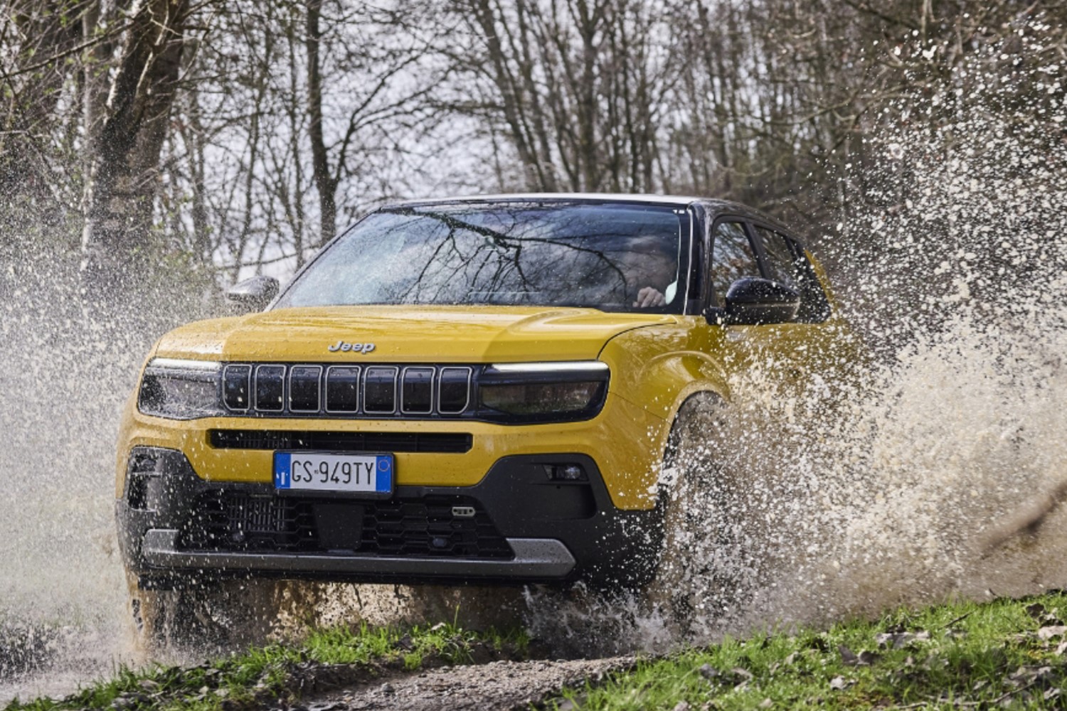 水しぶきを上げて悪路を走るジープのEV「アベンジャー」