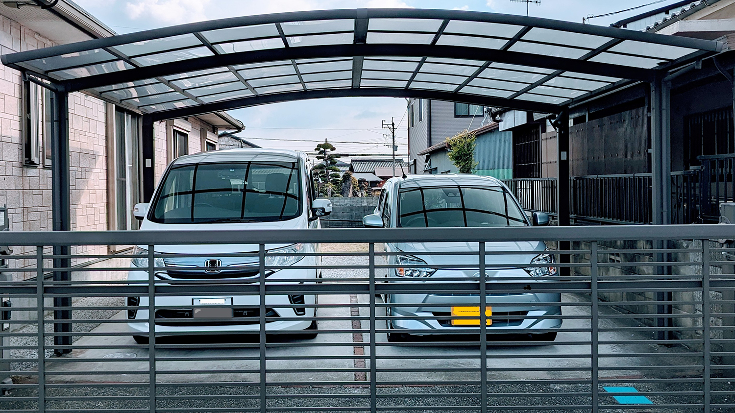 普通乗用車と軽自動車が並ぶ駐車場